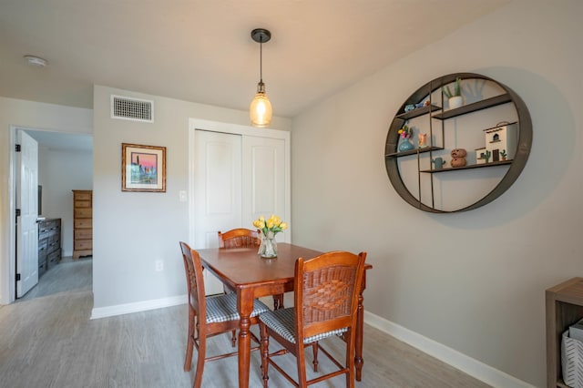 dining room featuring visible vents, baseboards, and wood finished floors