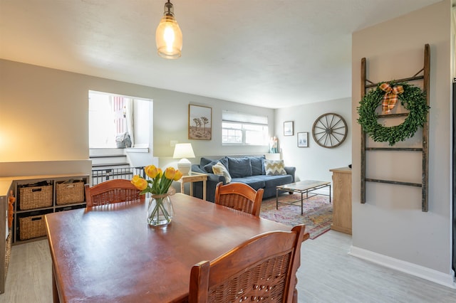 dining area featuring light wood-style floors and baseboards