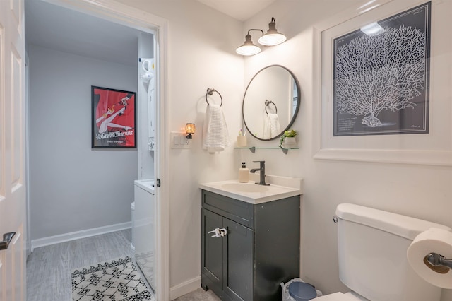bathroom featuring vanity, baseboards, and toilet