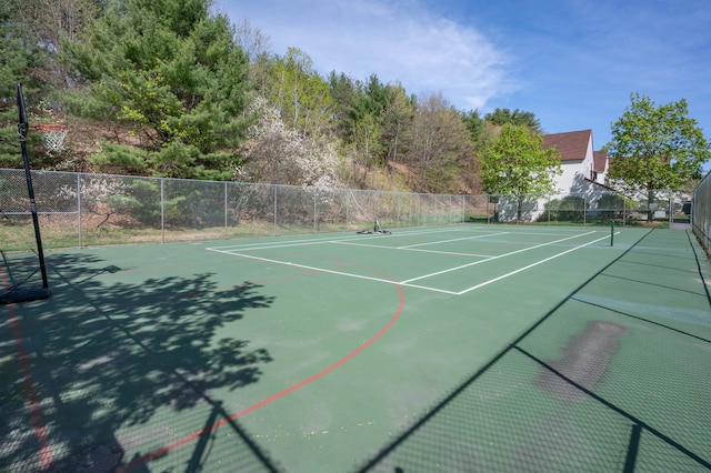 view of tennis court with fence and community basketball court