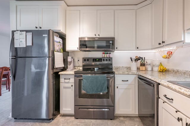 kitchen featuring light stone counters, white cabinetry, and stainless steel appliances