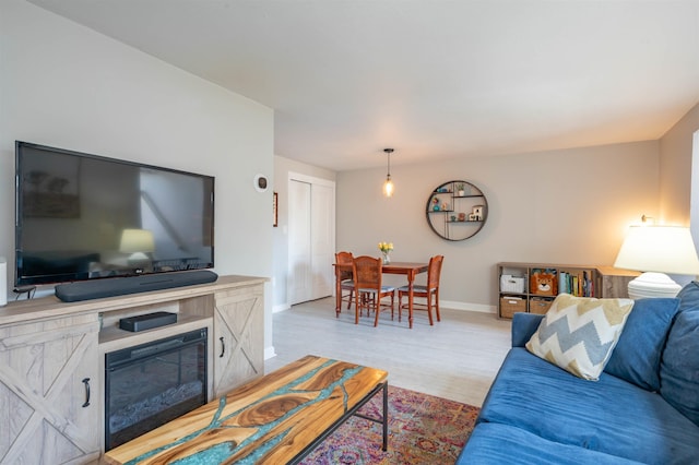 living area with baseboards and light wood-style flooring