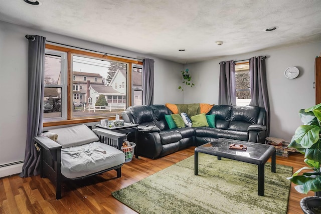 living area with baseboard heating, recessed lighting, and wood finished floors