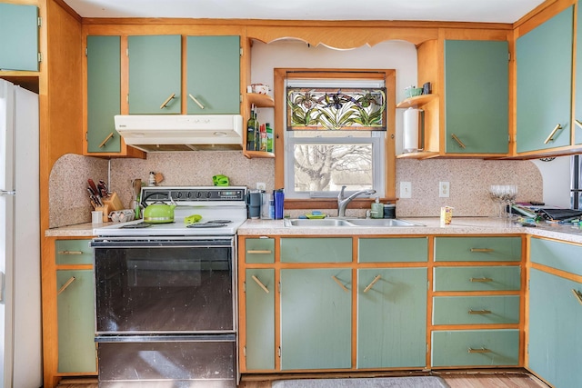 kitchen with a sink, electric stove, freestanding refrigerator, decorative backsplash, and under cabinet range hood