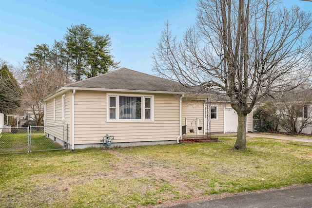 bungalow featuring fence, a shingled roof, a gate, and a front lawn