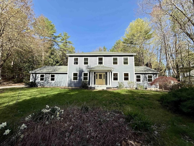 colonial home featuring a front lawn