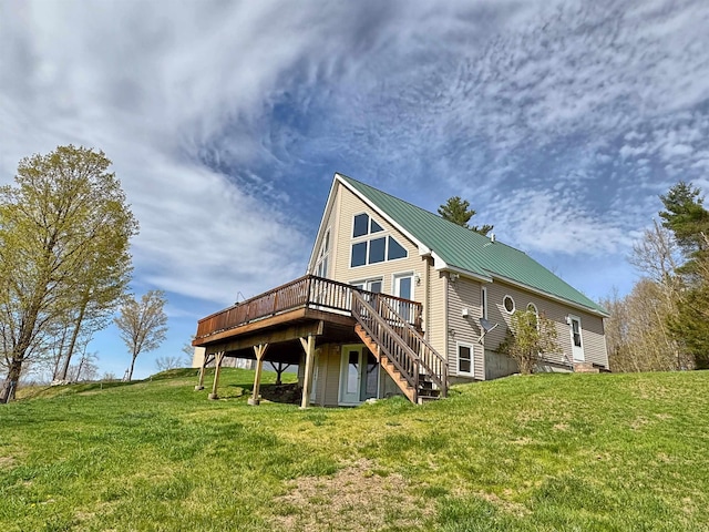 rear view of house with a yard, a deck, metal roof, and stairs
