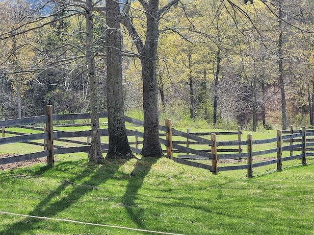 view of yard featuring fence and a wooded view