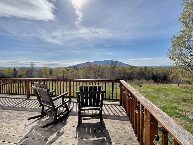 deck featuring a mountain view and a yard