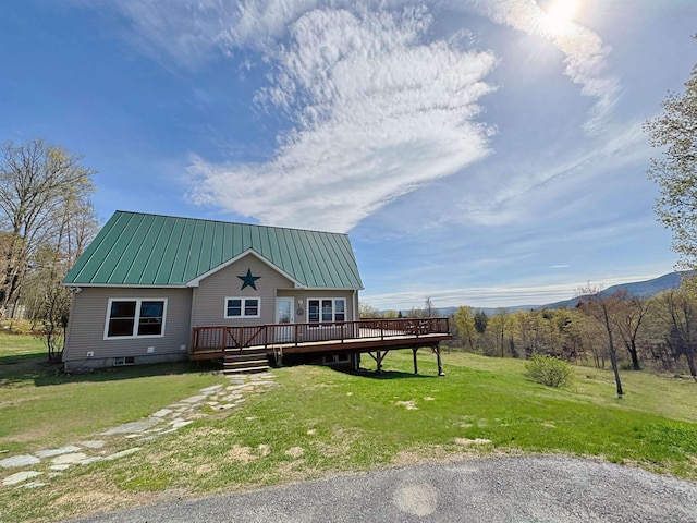 view of front of house with a front lawn, a deck, and metal roof