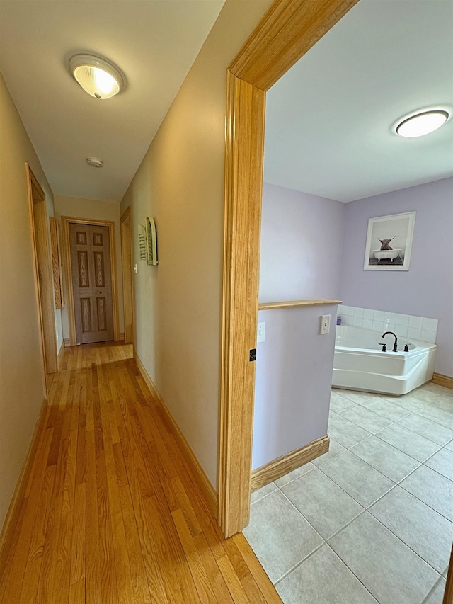hall featuring baseboards and wood finished floors