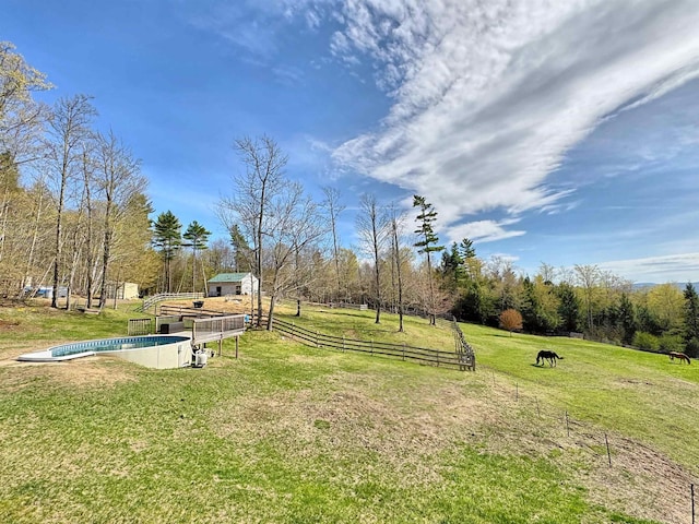 view of home's community featuring a yard, a swimming pool, fence, and an outdoor structure
