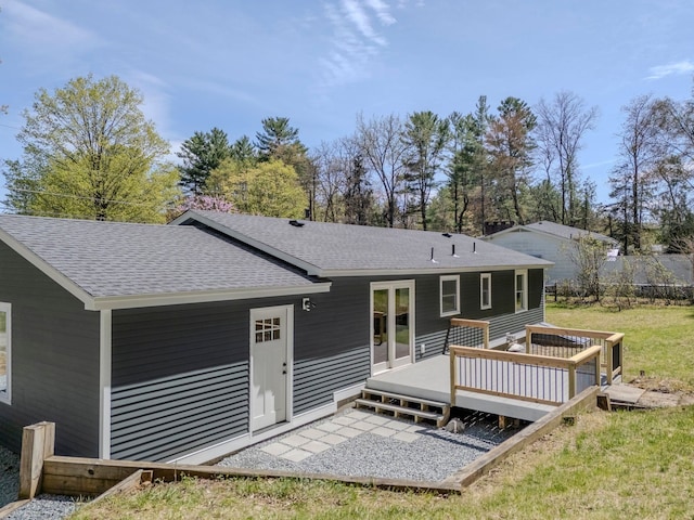back of property with a wooden deck and roof with shingles
