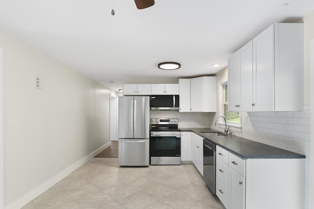kitchen featuring dark countertops, white cabinets, tasteful backsplash, a sink, and stainless steel appliances