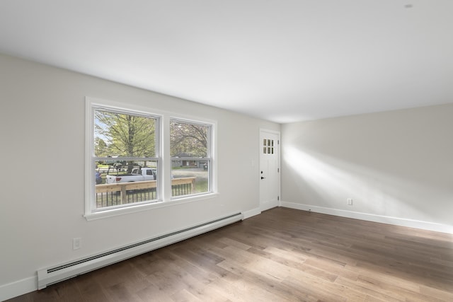 interior space with baseboards, a baseboard radiator, and wood finished floors