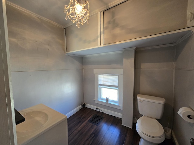 bathroom featuring crown molding, wood finished floors, toilet, baseboards, and a notable chandelier