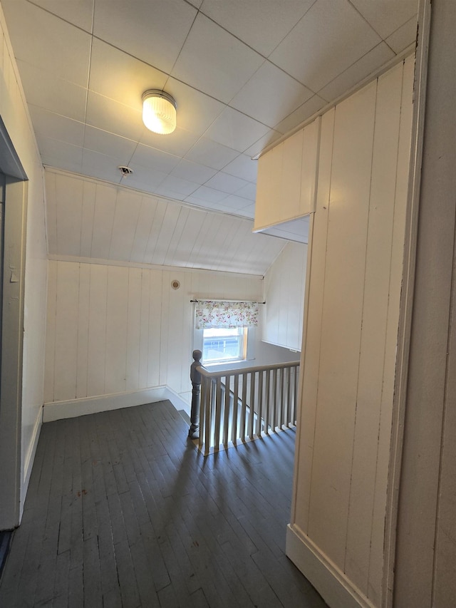 additional living space with baseboards and dark wood finished floors