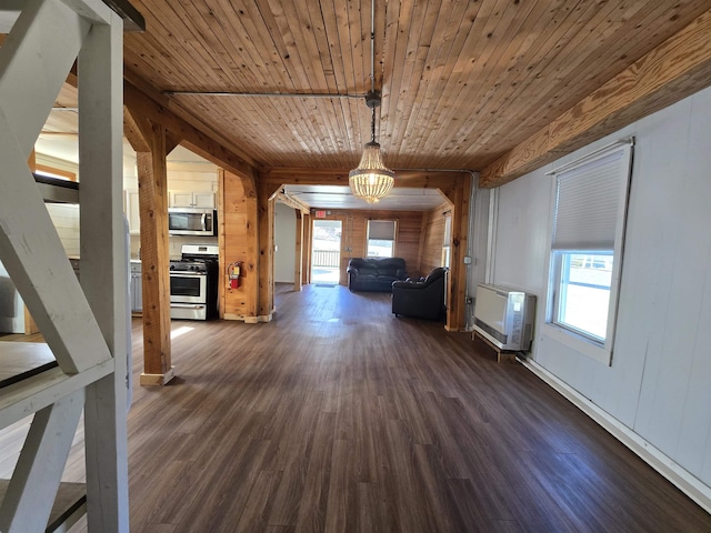 interior space featuring wood ceiling, an inviting chandelier, wooden walls, heating unit, and dark wood-type flooring
