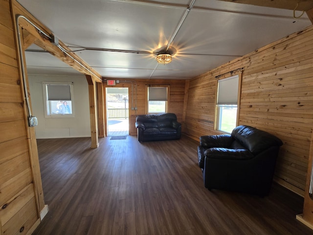 living area with wood walls and dark wood-type flooring