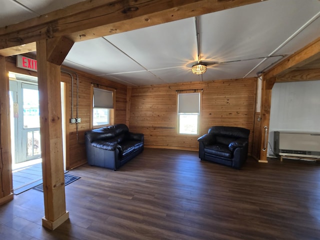 living area featuring wooden walls, heating unit, and wood finished floors
