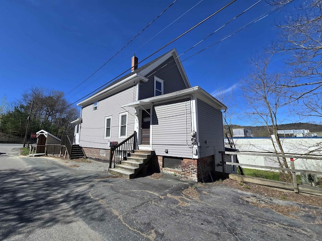 view of front of home with entry steps and fence