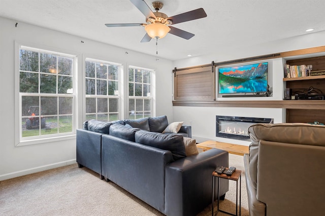 carpeted living area with baseboards, a ceiling fan, and a wealth of natural light