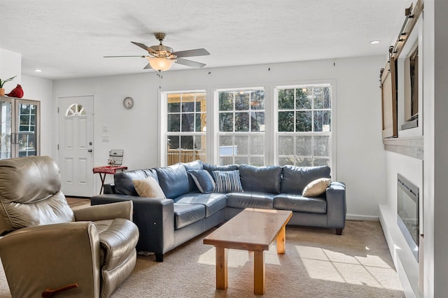 living room with light carpet, ceiling fan, recessed lighting, a barn door, and a textured ceiling