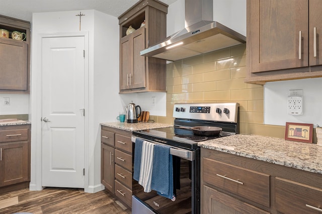 kitchen with dark wood-type flooring, open shelves, wall chimney exhaust hood, and stainless steel electric range oven