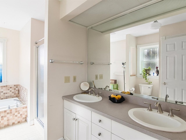 full bathroom featuring double vanity, a sink, a stall shower, and toilet