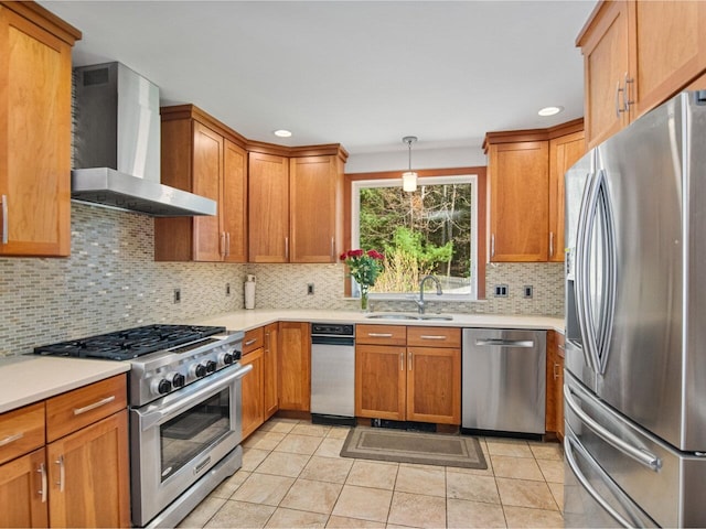 kitchen featuring appliances with stainless steel finishes, tasteful backsplash, a sink, light countertops, and wall chimney exhaust hood
