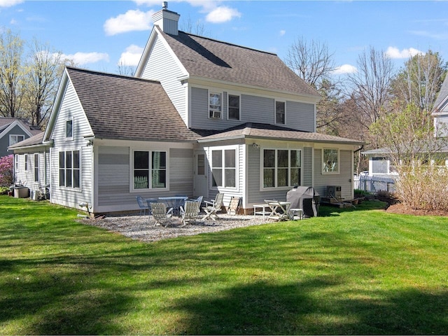 back of property featuring cooling unit, a chimney, a shingled roof, a patio area, and a yard