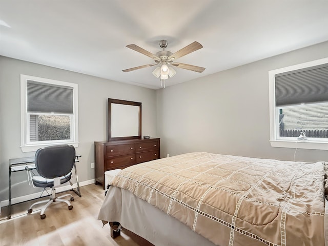 bedroom with light wood-style floors, baseboards, and ceiling fan