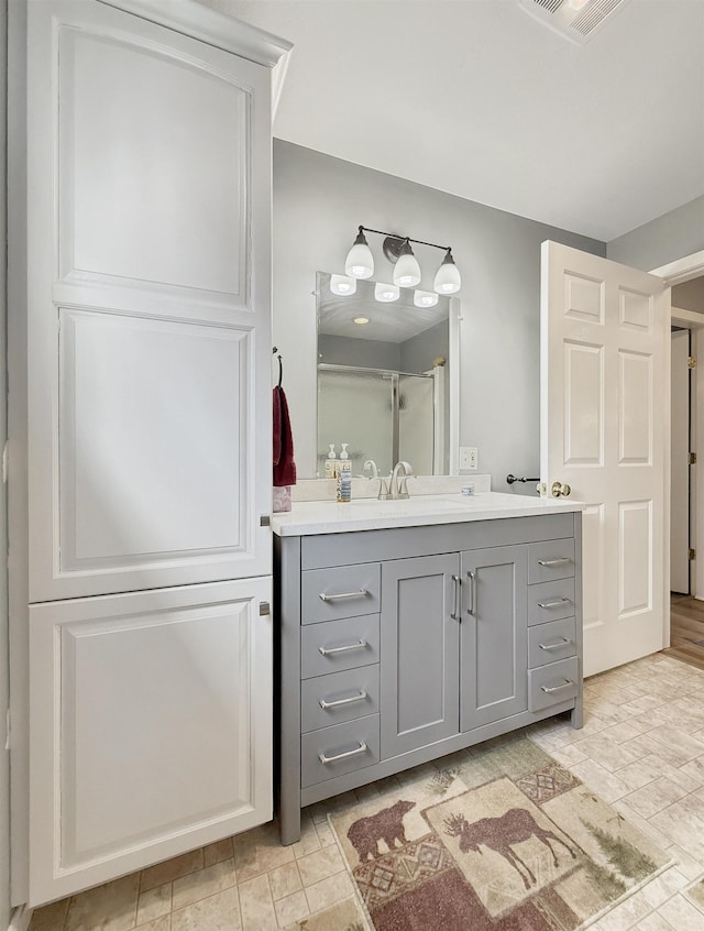 full bathroom with visible vents, an enclosed shower, and vanity