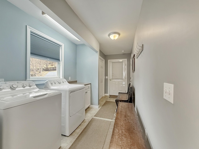 clothes washing area with cabinet space, baseboards, and washing machine and dryer
