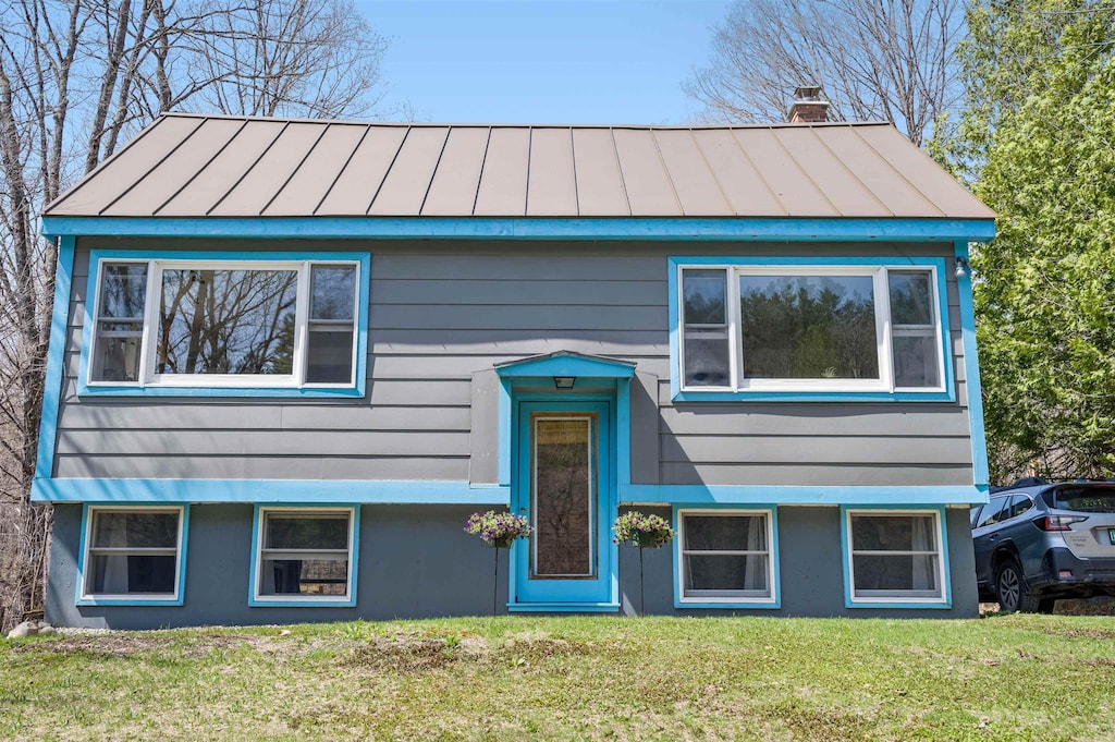 88 N Calais Rd, Calais, VT 05650 - raised ranch featuring a front yard, metal roof, a chimney, and a standing seam roof