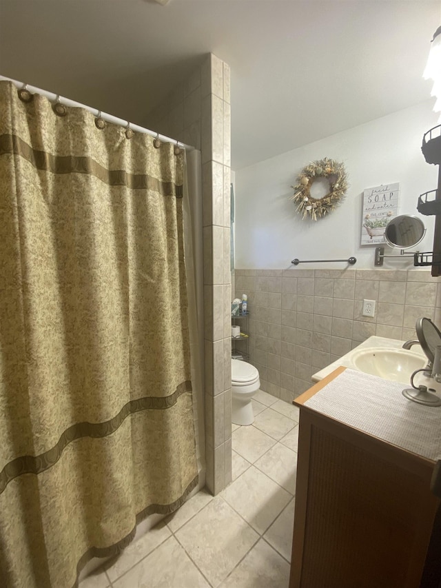full bathroom with vanity, wainscoting, toilet, tile walls, and tile patterned floors
