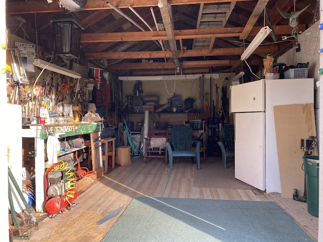 garage featuring freestanding refrigerator and a workshop area