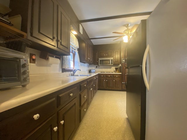 kitchen with dark brown cabinets, ceiling fan, appliances with stainless steel finishes, a sink, and light countertops