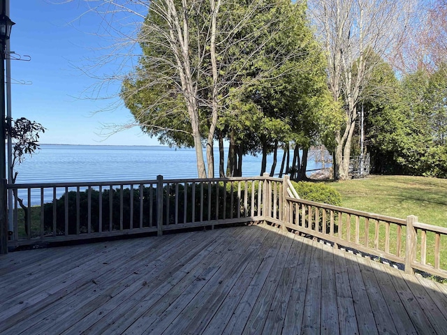 wooden terrace featuring a water view and a yard