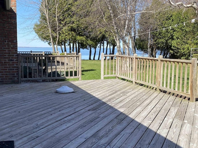 wooden deck with a water view and a yard