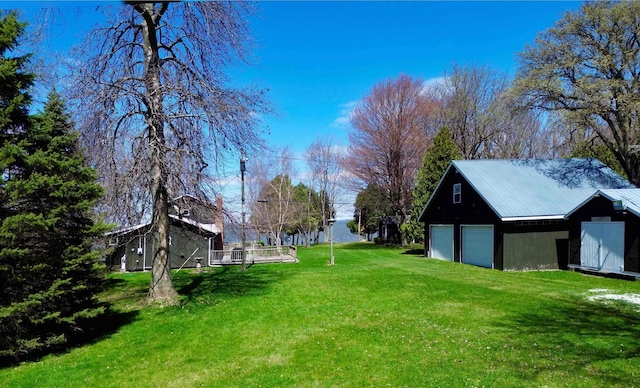 view of yard featuring a detached garage and an outdoor structure