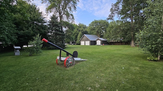 view of yard with a detached garage and an outdoor structure