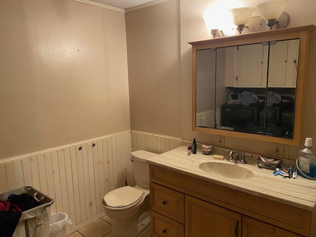 32 Myrtle St, Springfield, VT 05156 - bathroom featuring wainscoting, toilet, vanity, wooden walls, and tile patterned flooring