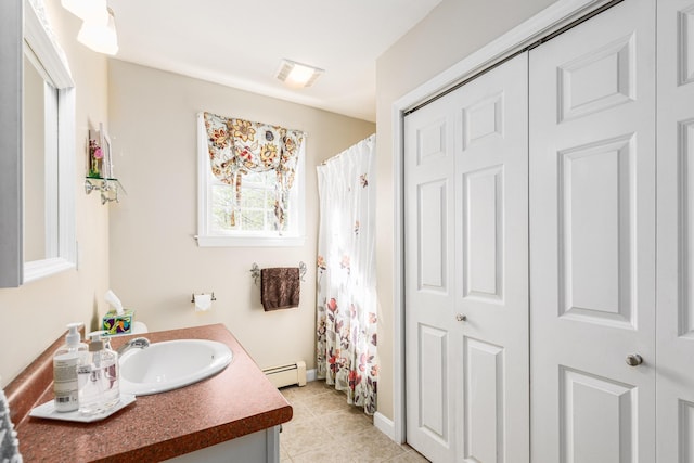 bathroom with vanity, a closet, and a baseboard radiator