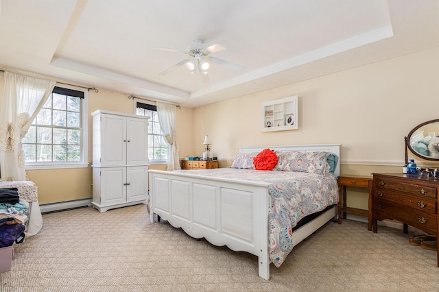 bedroom with light colored carpet, a baseboard radiator, ceiling fan, and a tray ceiling