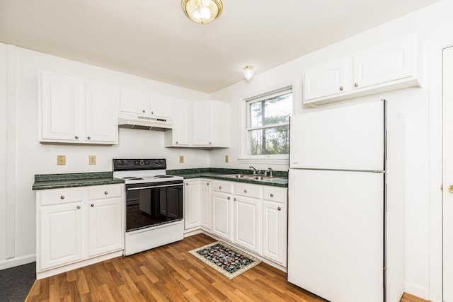 kitchen with dark countertops, white appliances, white cabinetry, wood finished floors, and under cabinet range hood