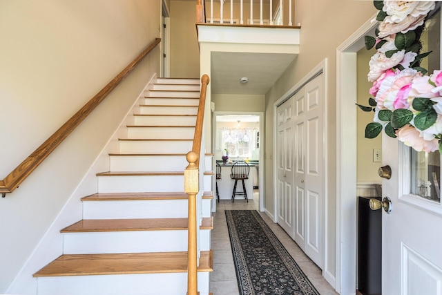 entryway with stairs and light tile patterned floors