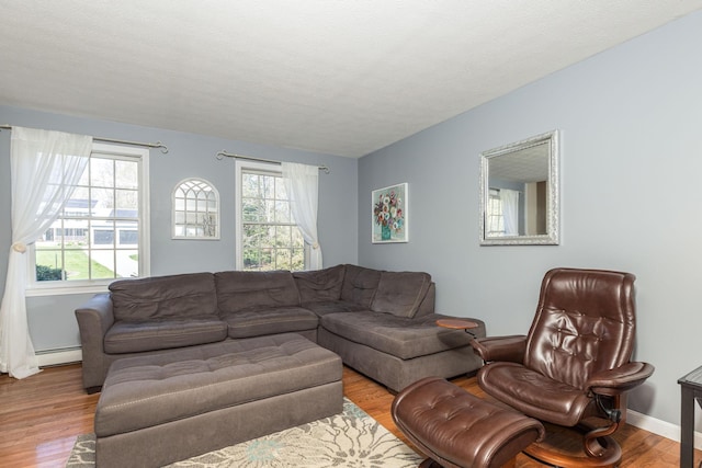 living room with baseboards, wood finished floors, and a baseboard radiator