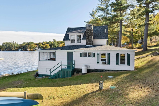 view of front of property featuring a water view, a front yard, and roof with shingles