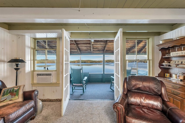 interior space with wooden walls, carpet floors, cooling unit, and a water view